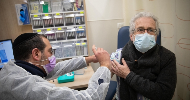 Homem recebe vacina da Covid-19 em posto de vacinação de Jerusalém, em 30 de dezembro de 2020. (Foto: Noam Revkin Fenton/Flash90)