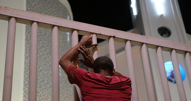 Homem do lado de fora de igreja fechada no Rio de Janeiro. (Foto: Ricardo Moraes/Reuters)