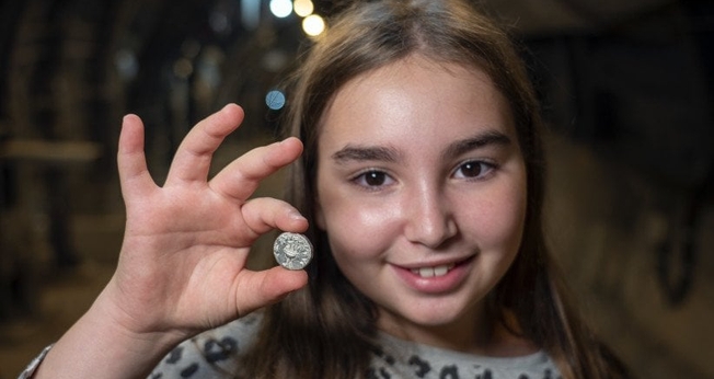 Liel Krutokop, de 11 anos, com a moeda que encontrou. (Foto: Yaniv Berman/Cidade de Davi e Autoridade de Antiguidades de Israel)