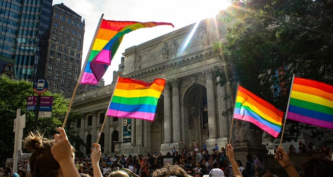 Pessoas carregam a bandeira utilizada como símbolo LGBT. (Foto: Pixabay)