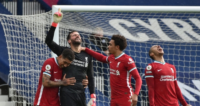 Alisson Becker, goleiro do Liverpool, aponta para o céu após surpreendente vitória. (Foto: Rui Vieira/Reuters)