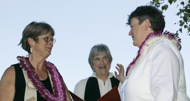 Pastora da PCUSA, Jane Spahr (ao centro) celebra um casamento homossexual, entre Sherrie Holmes (esquerda) e Sara Taylor (direita).