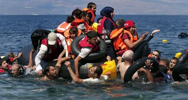 Sírios e afegãos resgatados após embarcação que levava cerca de 100 pessoas naufragar nas proximidades da ilha grega. (Foto: Alkis Konstantinidis/Reuters)