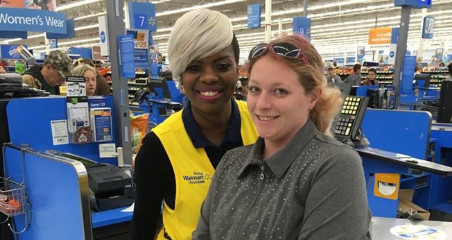 A funcionária Sharnique Dasant ao lado da cliente Ashley Jordan, em frente ao caixa do Walmart. (Foto: Reprodução/Facebook)