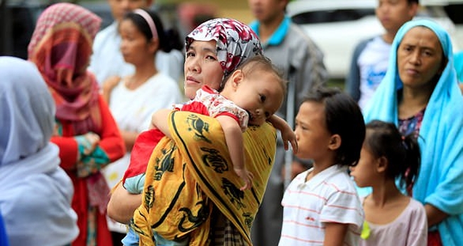 Mãe segura seu filho em meio ao caos instalado nas Filipinas, após cerco de terroristas. (Foto: Reuters)