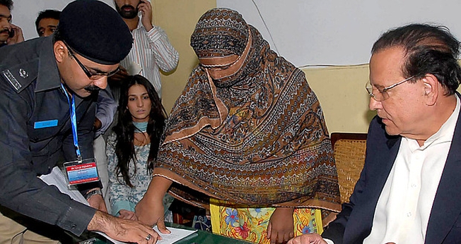 Asia Bibi coloca sua digital em um documento de recurso contra a condenação de sentença de morte. (Foto: AFP)