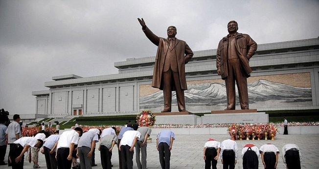 Norte-coreanos curvam-se diante das estátuas de bronze dos falecidos líderes Kim Il Sung e Kim Jong Il no Grande Monumento da Colina Mansu. (Foto: AP)