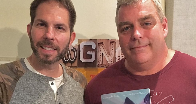 John Gray (à direita) e seu livro infantil “God Needed a Puppy”. (Foto: Reprodução/ WGNA)