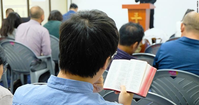 Cristãos chineses leem a Bíblia em uma igreja em Nairóbi. (Foto: Reprodução/CNN)