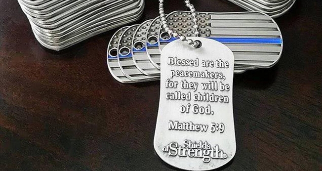 Dog tag com a inscrição de Mateus 5:9, que diz "Bem-aventurados os pacificadores, porque serão chamados filhos de Deus". (Foto: Reprodução/Shields of Strength)
