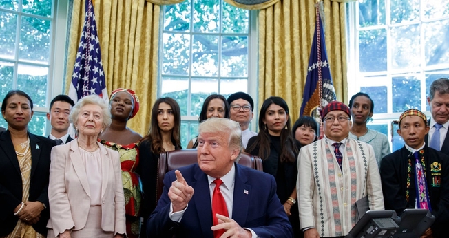 Presidente Trump com o pastor Hkalam Samson, de casaco claro e chapéu, em reunião com sobreviventes da perseguição religiosa em julho. (Foto: Alex Brandon/Associated Press)