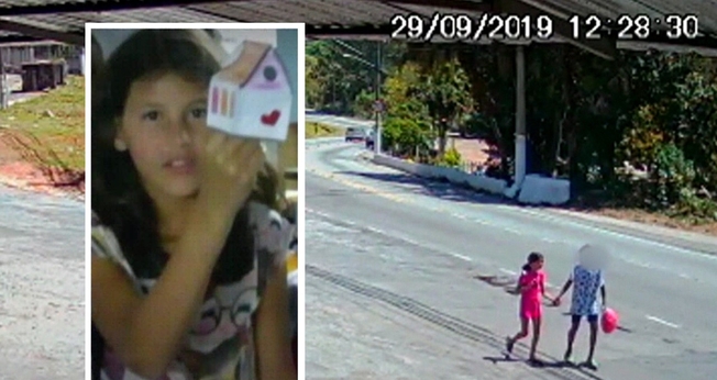 A menina Raíssa de mãos dadas com adolescente, em Perus. (Foto: Reprodução/TV Globo)