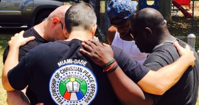 Policiais oram juntos e pelas pessoas nas ruas. (Foto: Reprodução/God Reports)