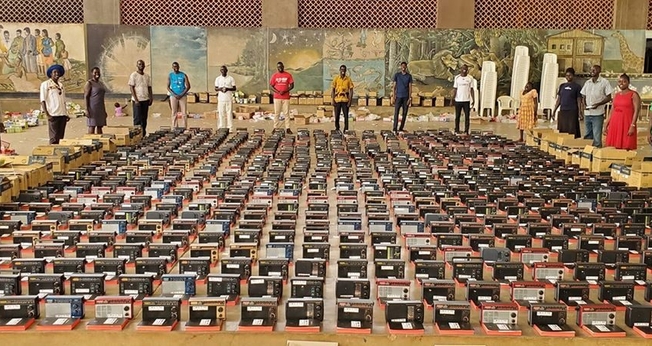 Uma equipe da Fundação Irene Gleeson, em Uganda, ora diante de Bíblias, rádios transistorizados que devem ser distribuídos a 1000 famílias nos distritos de Kitgum e Lamwo. (Foto: Reprodução/UGCN).