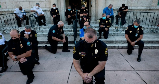 Policiais se ajoelharam durante um comício em Coral Gables, Flórida, no sábado, em resposta à morte de George Flay. (Foto: Eva Marie Uzcategui / AFP via Getty Images)