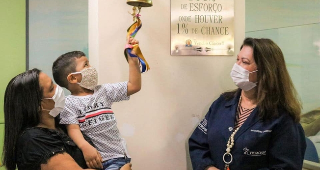 Brener Lorenzo, de 4 anos, toca o sino da cura após dois anos e meio de tratamento. (Foto: Governo do Amazonas)