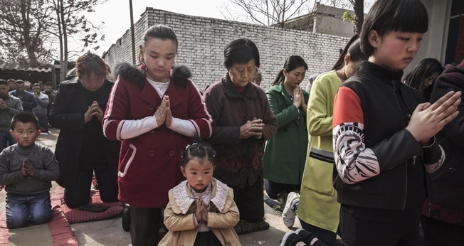 Cristãos chineses oram ajoelhados durante um culto de Páscoa em uma igreja não oficial. (Foto: Getty Images / Kevin Frayer)
