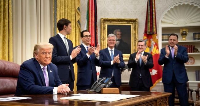 Donald Trump e equipe em anúncio do acordo entre os Emirados Árabes Unidos e Israel na Casa Branca. (Foto: Brendan Smialowski/AFP via Getty Images)