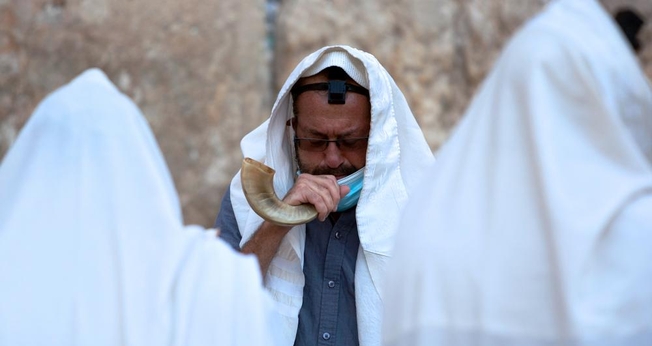 Um judeu ultraortodoxo toca um shofar, um instrumento musical feito de chifre de animal, enquanto ora antes do ano novo judaico no Muro das Lamentações. (Foto: AP Photo / Sebastian Scheiner)