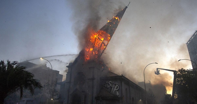 Igreja em chamas após ataque de manifestantes encapuzados em Santiago, no Chile. (Foto: AFP/Martin Bernetti)