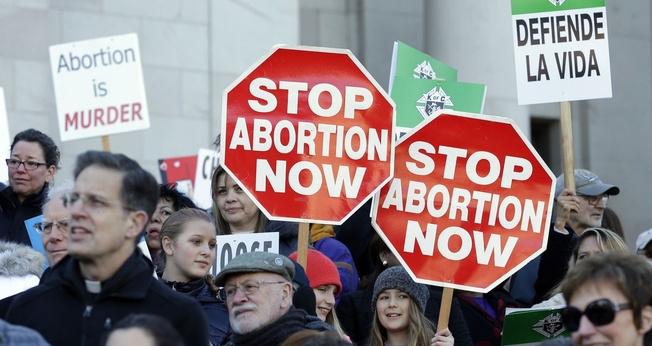 Manifestantes pró-vida protestam contra o aborto, segurando cartazes que dizem "Parem o Aborto Agora", enquanto ouvem os palestrantes em 23 de janeiro de 2017, no Capitólio em Olympia. (Foto: AP / Ted S. Warren)