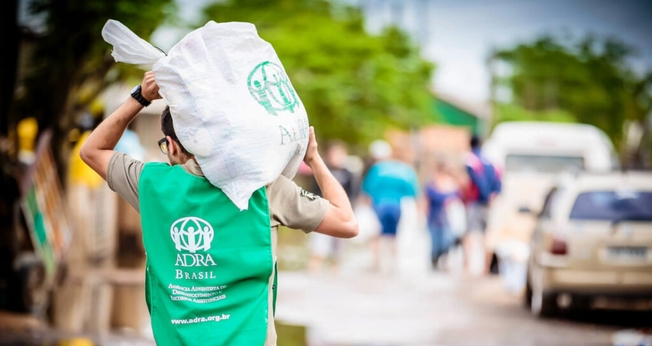 Voluntário carrega doações durante uma das ações realizadas pela agência humanitária (Foto: ADRA Brasil)
