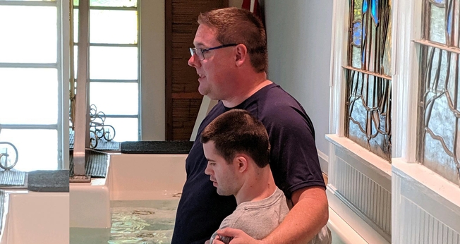 Pastor Jim McCaffrey batiza jovem com deficiência nos EUA. (Foto: Gunpowder Baptist Church)