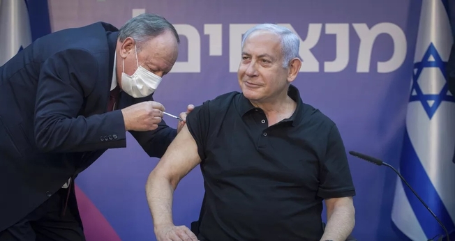 Primeiro-ministro de Israel, Benjamin Netanyahu, recebe segunda dose da vacina da Pfizer-BioNTech contra a Covid-19 no dia 9 de janeiro. (Foto: Miriam Elster /Pool Photo via AP)