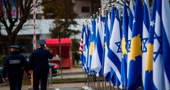 Policiais passam por bandeiras de Kosovo e Israel expostas durante uma cerimônia em Pristina em fevereiro, depois que os países estabeleceram relações diplomáticas. (Foto: Armend Nimani / AFP / Getty Images)