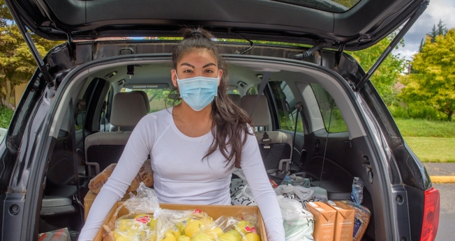Diana Vergara possui uma caixa de alimentos frescos doada a sua família pela Visão Mundial na Igreja Adventista de Auburn City em Auburn, Washington. (Foto: Visão Mundial / Laura Reinhardt).