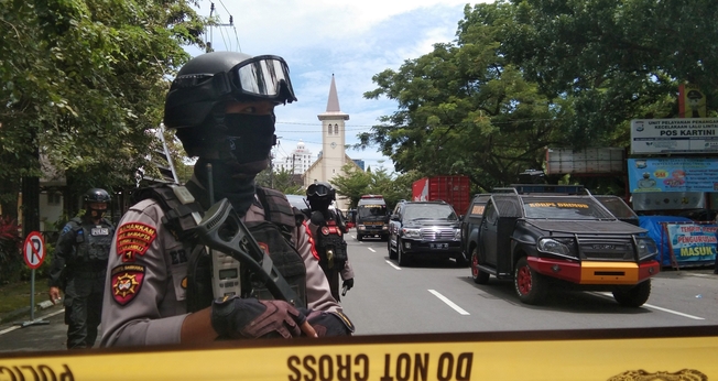 Policiais montam guarda ao longo de uma rua fechada após explosão em frente a igreja, na Indonésia. (Foto: Antara Foto/Arnas Padda via Reuters)