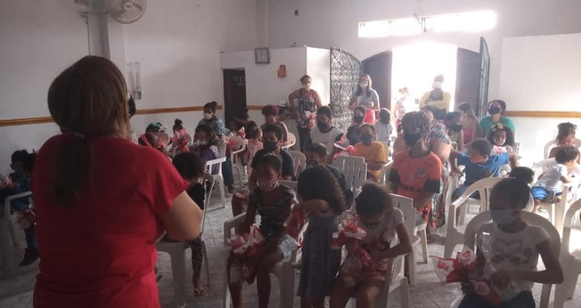 A diretora Dilene Santos ora com as crianças do Projeto Kids Crescer e Vencer. (Foto: Reprodução / Facebook)
