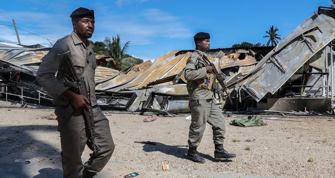 Soldados do exército moçambicano passam por um prédio destruído por insurgentes ligados ao Estado Islâmico em Palma, Moçambique. (Foto: João Relvas/EPA/Shutterstock)