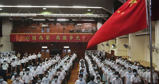 Alunos participam de uma cerimônia de hasteamento da bandeira, no Dia da Educação para a Segurança Nacional, numa escola em Hong Kong, 15 de abril de 2021. (Foto: AP Photo/Kin Cheung)