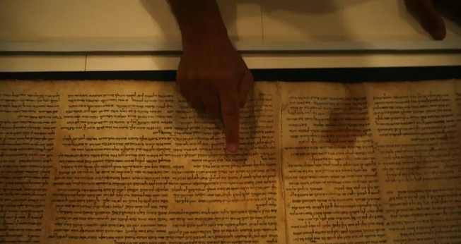 Adolfo Roitman, curador dos Manuscritos do Mar Morto, aponta para o Manuscrito de Isaías original, um dos Manuscritos do Mar Morto. (Foto: Baz Ratner / Reuters)