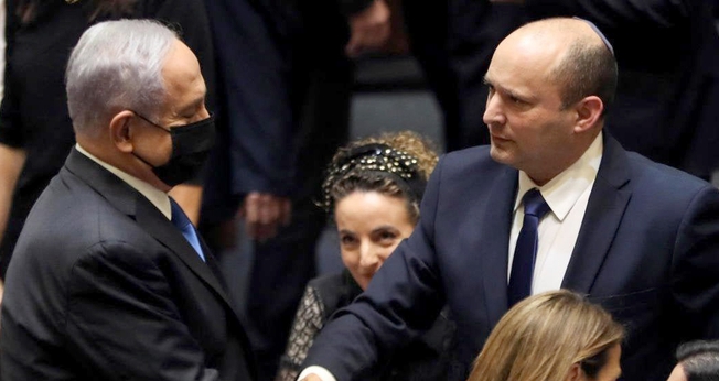 Benjamin Netanyahu e Naftali Bennett apertam as mãos após votação no Knesset. (Foto: Reuters/Ronen Zvulun)