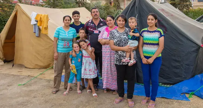 Família em frente a sua tenda após ter que fugir do Iraque por conta dos ataques do Estado Islâmico. (Foto: Portas Abertas)