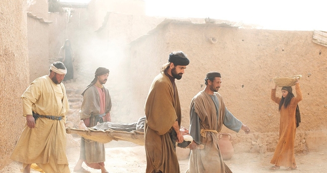 Amigos levam paralítico até Jesus para ser curado. (Foto: FreeBible)