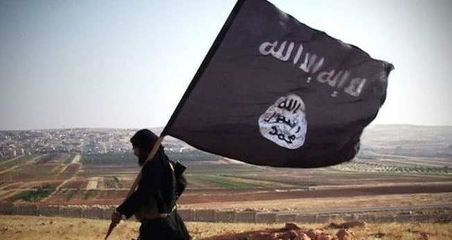 Militante islâmico com a bandeira do grupo terrorista. (Foto: Wikipedia)