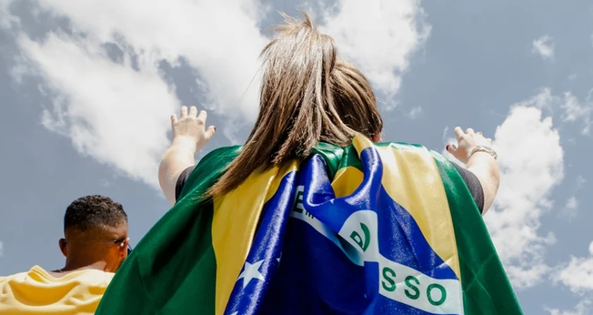 Jovem com bandeira do Brasil em momento de oração. (Foto: The Send Brasil)