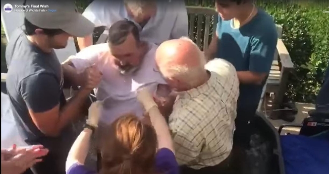Tommy Dale Reid, sendo batizado nas águas. (Foto: Captura de tela/Facebook Hospice of Wichita Falls)