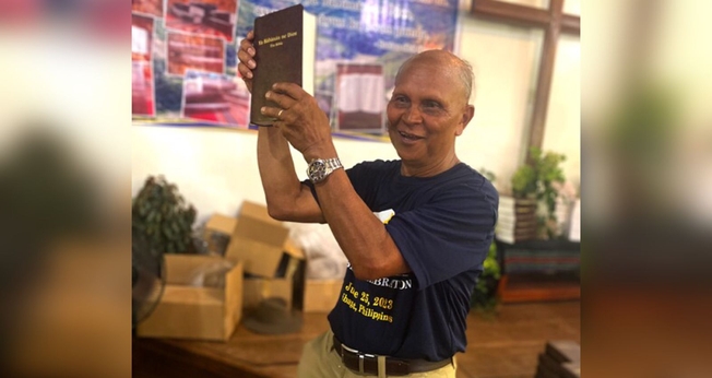 Nard Pugyao segurando a Bíblia no idioma Isnag. (Foto: Wycliffe Bible Translators)