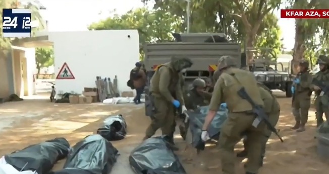 Corpos dos moradores do kibutz Kfar Aza são retirados por policiais israelenses. (Captura de tela/YouTube i24News)