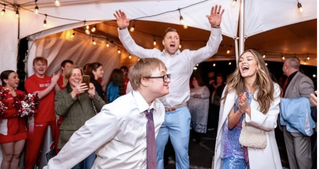 Participantes do evento Noite para Brilhar e Tim Tebow ao fundo. (Foto: X/Tim Tebow)