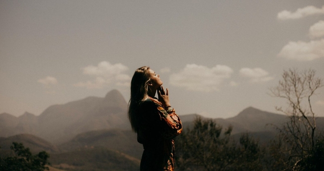 Mulher orando. (Foto: Reprodução/Unsplash/Marcos Paulo Prado)