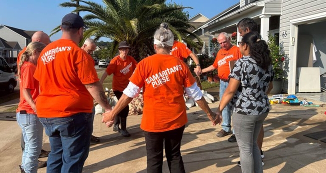 Roda de oração entre as vítimas e os voluntários. (Foto: Reprodução/Samaritan's Purse)