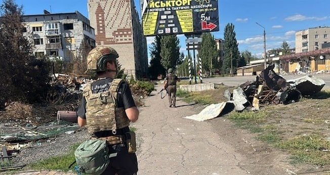 Soldado ucraniano escolta missionários por uma cidade destruída nos arredores de Pokrovsk. (Foto: Free Burma Rangers)