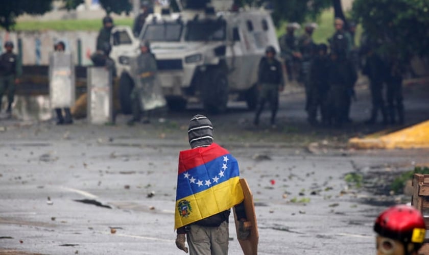 Manifestante de frente para as Forças Armadas em protesto contra Nicolás Maduro, na Venezuela. (Foto: Reuters/Carlos Garcia Rawlins)