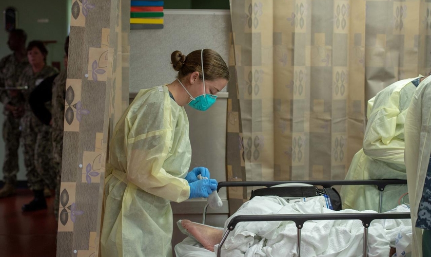 Mulher trata paciente em hospital no navio USNS Mercy, implantado para tratar pacientes com Covid-19 na Califórnia. (Foto: US Navy/Erwin Jacob Miciano/Reuters)