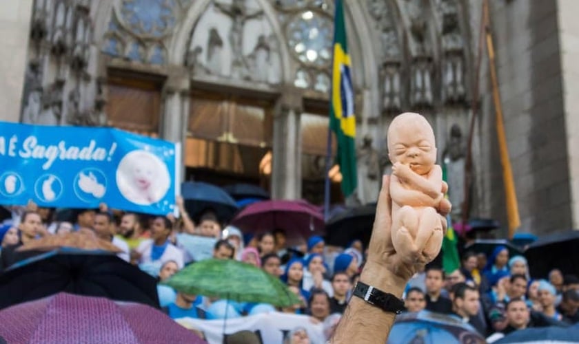 Manifestante pró-vida segura boneco de feto em protesto contra aborto. (Foto: Marcha Pela Vida Brasil)